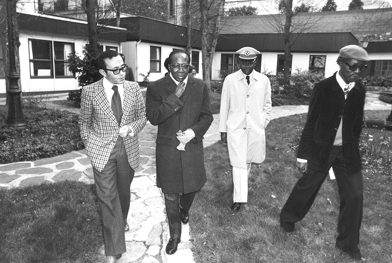 Léopold Sédar Senghor, président du Sénégal, Béchir Ben Yahmed (veste à carreaux), directeur de "Jeune Afrique", et Jean-Pierre Ndiaye (veste sombre, à dr.), dans le jardin de l'avenue des Ternes, alors siège du journal, à Paris, en janvier 1979. © Archives Jeune Afrique
