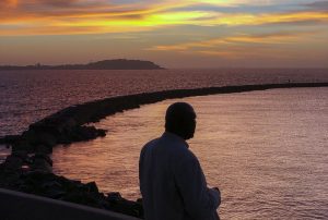 Bord de mer à Dakar. A man sings to the ocean in Dakar, Senegal on January 30, 2019. Outdoor exercise is a popular past time in Dakar, though as the capital grows and traffic increases, and desertification in the Sahara increases, air quality has become a concern for those who use the corniche area and beyond.  (Photo by Ashley Gilbertson / VII Photo) *** Local Caption *** Vie nocturne 
active activities activity dakar exercise exterior fit fitness outdoor running senegal weights wrestling
© Ashley Gilbertson/VII/REDUX-REA