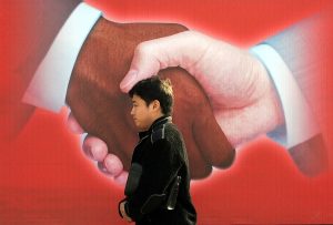 Un passant devant une affiche du sommet Chine-Afrique de novembre 2016, à Pékin. © Jason Lee/REUTERS