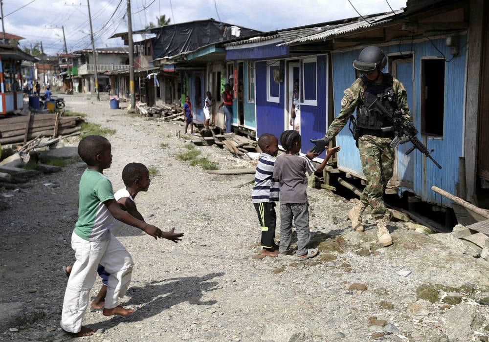 Des enfants saluent un soldat des Forces spéciales de la Marine colombienne, venues en renfort pour lutter contre la violence des gangs se disputant le contrôle de Buenaventura, le 27 mars 2014. &copy; Fernando Vergara/AP/SIPA