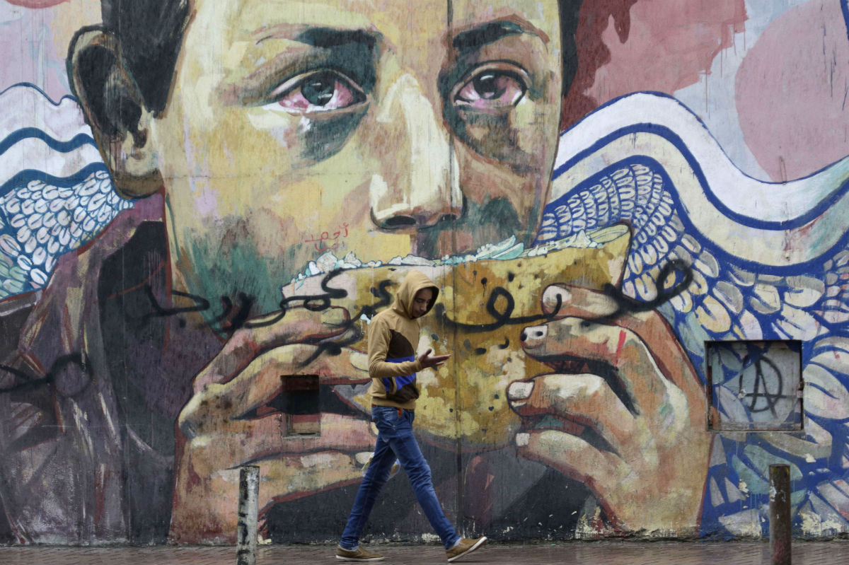 Un jeune homme passe près d'une fresque, place Tahrir, au Caire, en janvier 2016. &copy; Amr Nabil/AP/SIPA