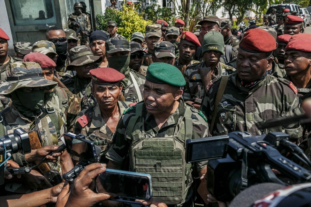 Des membres d’un contingent de l’armée malgache s’adressent aux médias sur une route près de leur camp, aux environs d’Antananarivo, le 11 octobre 2025.