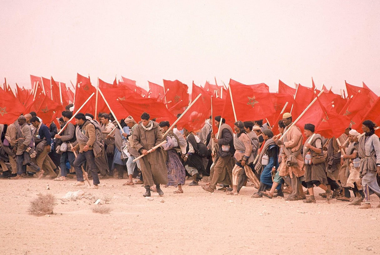 Plusieurs milliers de Marocains portant chacun un Coran et le drapeau de leur pays franchissent la frontière du Sahara occidental, à Tah, le 6 novembre 1975. © Frilet/SIPA