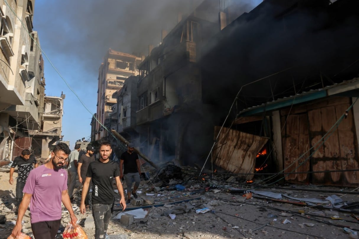 Des Palestiniens au milieu des décombres d’un bâtiment touché par une frappe aérienne israélienne à Gaza, le 13 octobre 2023. © MOHAMMED ABED / AFP