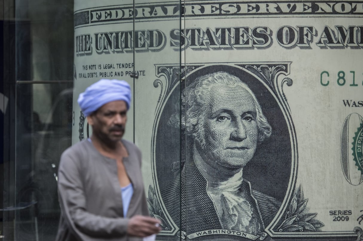 Un homme passe devant un magasin de change affichant un billet de banque géant en dollars américains, dans le centre du Caire, le 3 novembre 2016. © KHALED DESOUKI / AFP