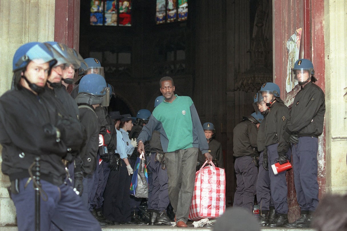 Un Malien sort de l'église Saint-Bernard, à Paris, le 23 août 1996, lors de l'évacuation par les forces de l'ordre françaises du bâtiment religieux, où s'étaient réfugiés pendant une cinquantaine de jours 300 Africains sans-papiers. &copy; Thomas Coex / AFP