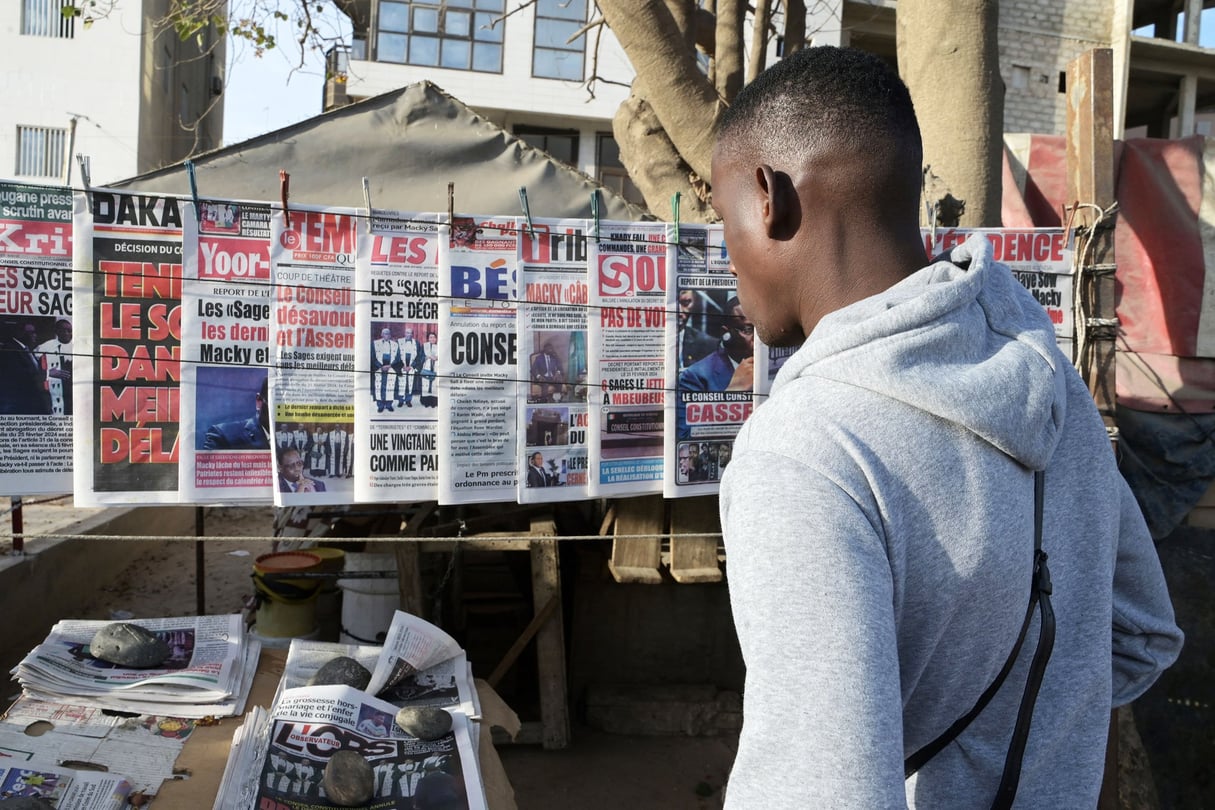 Des journaux en vente dans une rue de Dakar, le 16 février 2024. A Senegalese man reads the headlines of the newspapers on sale in a street in Dakar on February 16, 2024. Senegal’s Constitutional Council on February 16, 2024 overturned the postponement of this month’s presidential election, a historic decision that opens up a realm of uncertainty for the traditionally stable West African nation. 
President Macky Sall’s decision earlier this month to postpone the February 25 poll plunged Senegal into its worst crisis in decades, sparking widespread outcry and prompting deadly protests
© Seyllou/AFP