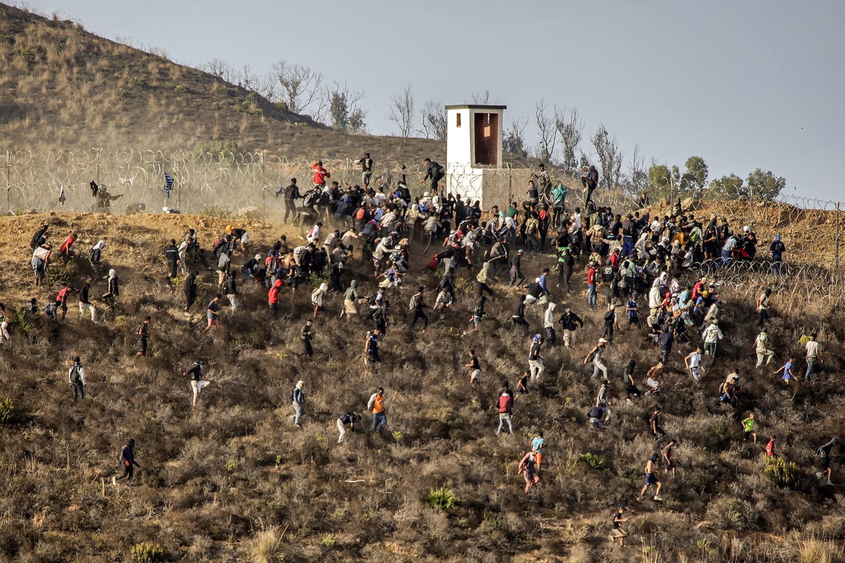 Des migrants tentent de franchir la frontière avec l’enclave africaine espagnole de Ceuta, dans le nord du Maroc, le 15 septembre 2024. © AFP