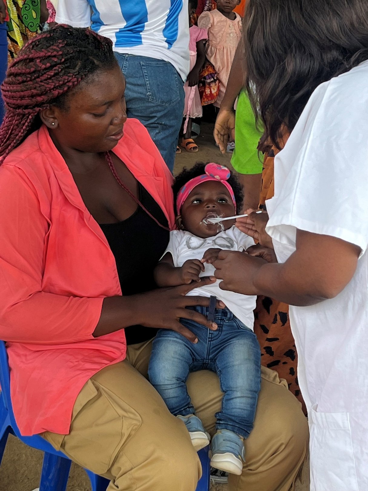  © Koung Sonya tient sa fille de 6 mois, Alexia, pendant qu’elle reçoit un traitement préventif du paludisme saisonnier (CPS), lors d’une activité de sensibilisation organisée à l’occasion de la Journée mondiale de lutte contre le paludisme, dans le village de Tsekane, district de Bafia, Cameroun.
Crédit photo : Taylor Prochnow, projet Unitaid Plus