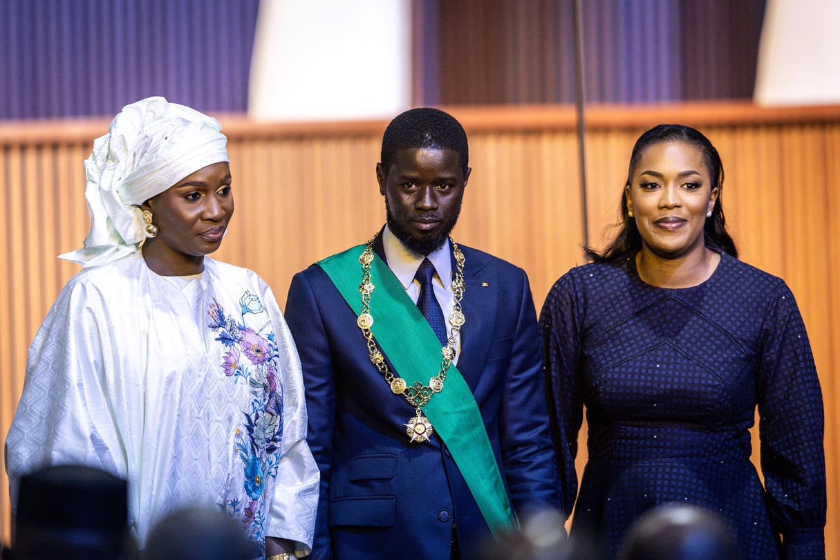 Bassirou Diomaye Faye et ses deux épouses Marie Khone Faye (à gauche) et Absa Faye (à droite) le 2 avril 2024. © JOHN WESSELS / AFP