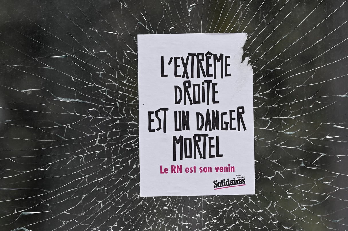 Une affiche laissée par des manifestants sur la vitrine d’un magasin vandalisé, à Caen (France), le 16 juin 2024. © Artur Widak / NurPhoto via AFP