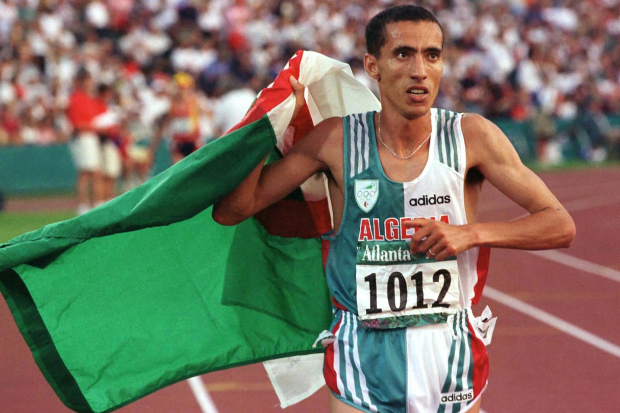 L’Algérien Noureddine Morceli, qui a remporté la médaille d’or au 1 500 m, aux JO d’Atlanta, fait un tour de stade pour fêter sa victoire, le 3 août 1996. © Jerry Lampen/REUTERS