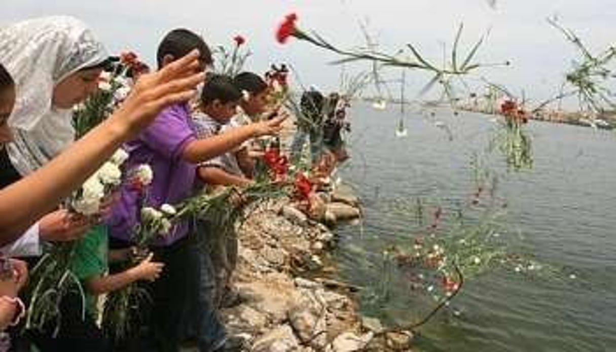 Des Palestiniens jettent des fleurs dans le port de Gaza, mardi 1er juin, en hommage aux victimes. © AFP