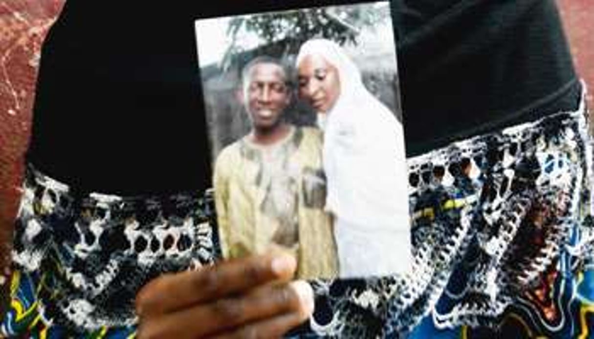 Kadiatou Barry tient une photo d’elle avec son mari, Alpha Oumar Diallo, mort le 28 septembre. © Luc Gnago/Reuters