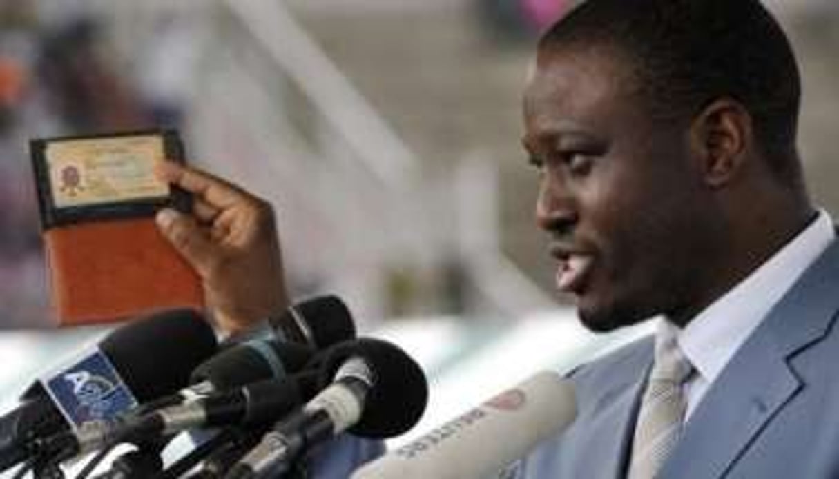 Guillaume Soro montre sa carte d’électeur dans le stade de Bouaké, le 3 octobre. © AFP