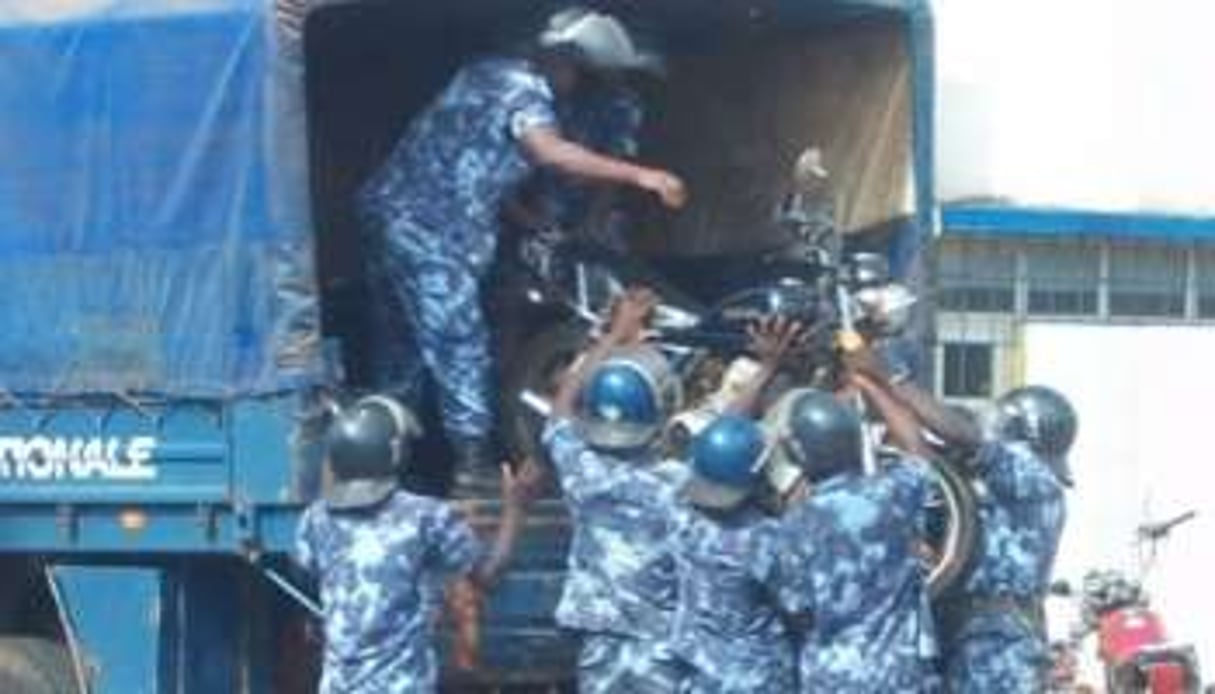 Membres des forces de l’ordre confiscant la moto d’un manifestant. © Jean-Claude Abalo, pour J.A.