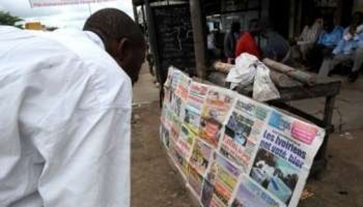 Un homme regarde les « Une » de journaux, le 1er novembre 2010 à Abidjan. © AFP