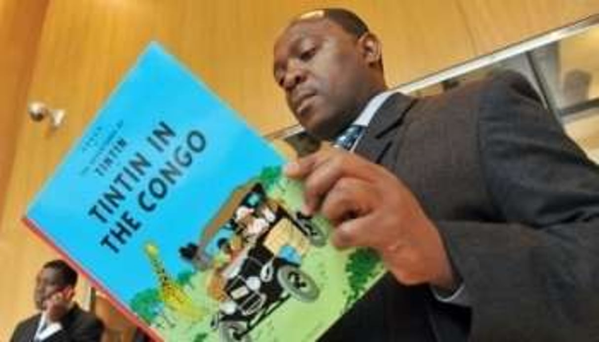 Bienvenu Mbutu tient une version anglaise de la BD mise en cause, le 22 novembre à Bruxelles. © AFP