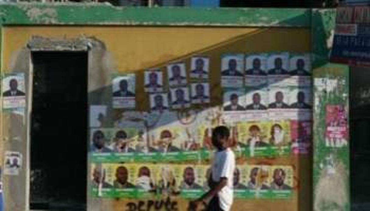 Un Haïtien passe devant des affiches électorales à Port-au-Prince le 24 novembre 2010. © AFP