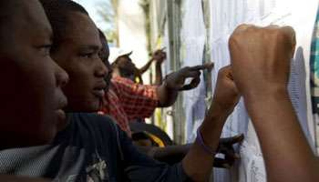 Des Haïtiens consultent les listes électorales le 28 novembre 2010 à Léogane. © AFP