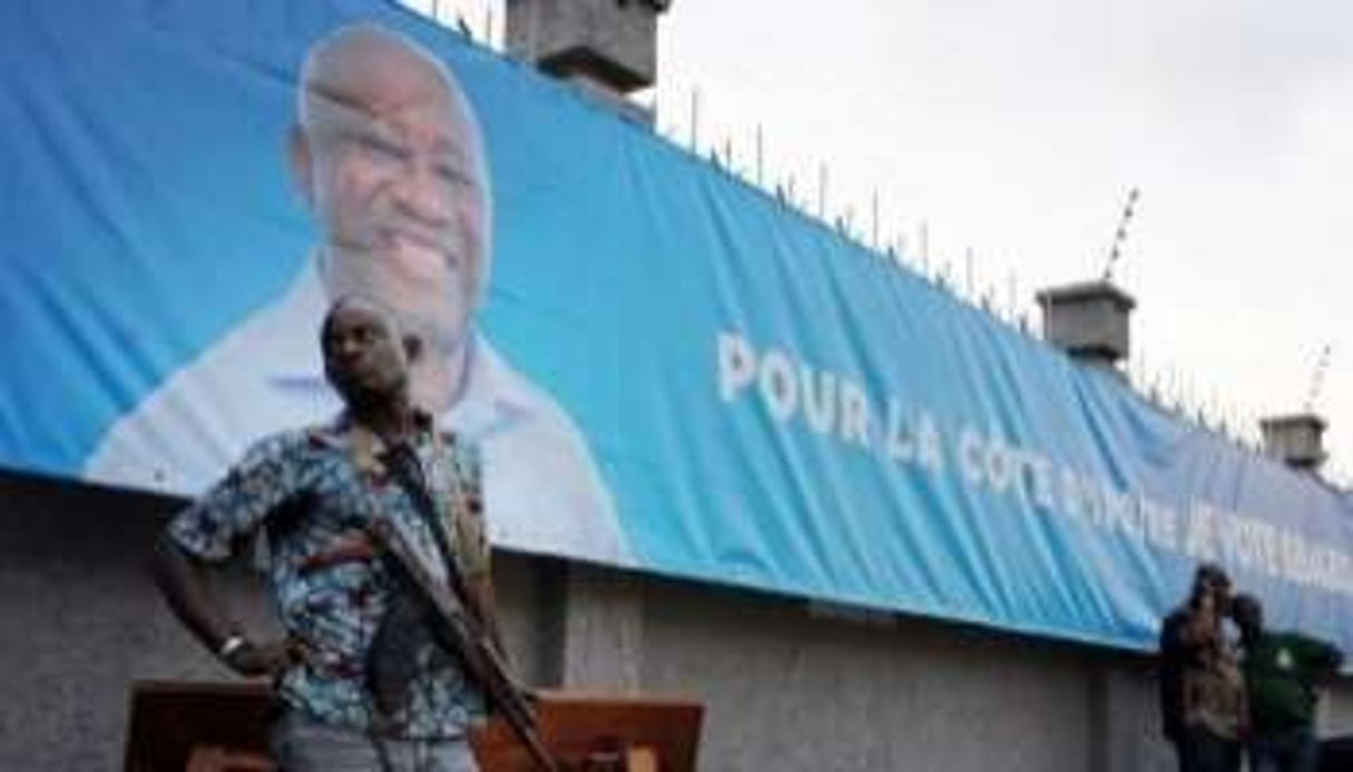 Un homme en arme devant le siège de campagne de Laurent Gbagbo le 2 décembre 2010 à Abidjan. © AFP
