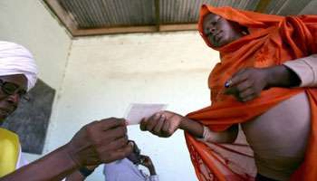 Une Soudanaise du Sud reçoit sa carte de vote pour le référendum de janvier 2011 à Al-Fasher. © AFP