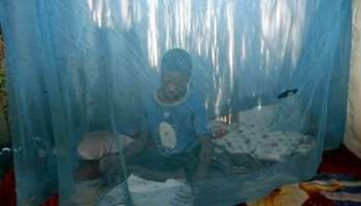 Un enfant sous une moustiquaire, pour se protéger contre le paludisme, au Mozambique en 2005. © AFP