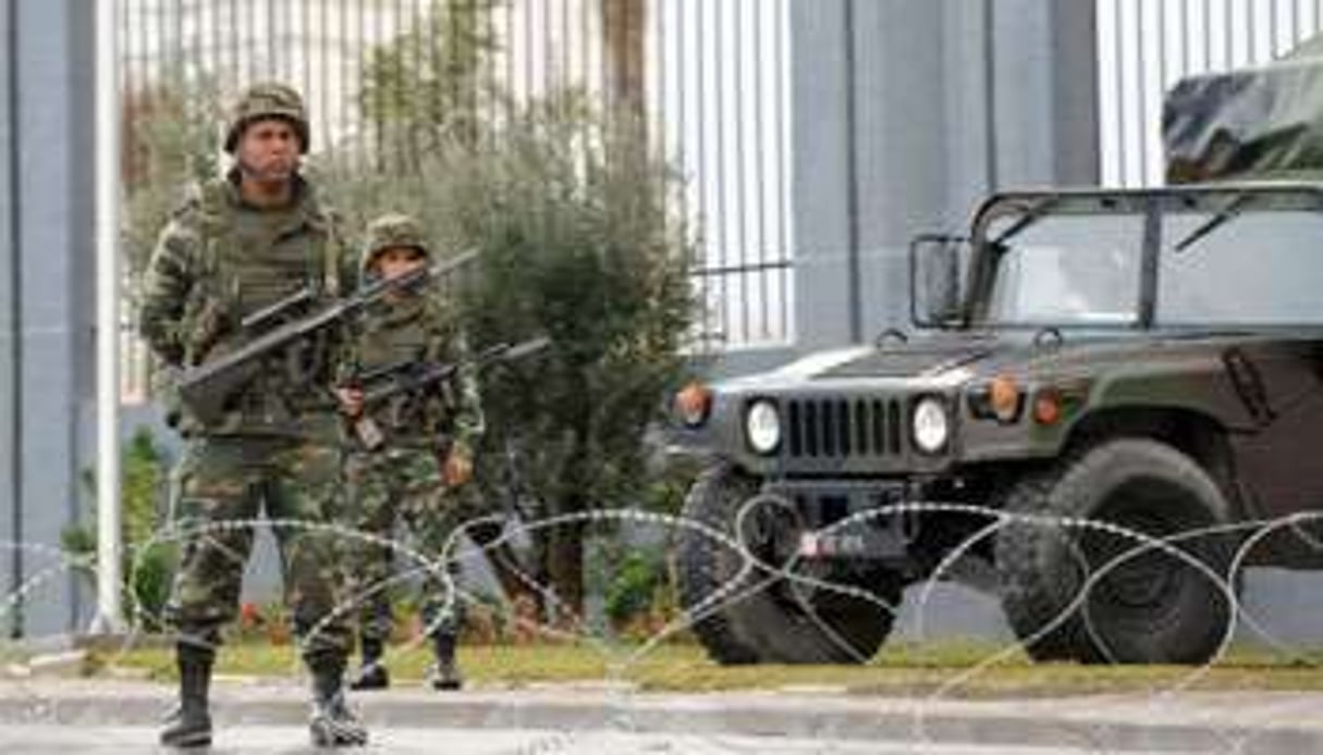 Des soldats tunisiens devant les locaux de la télévision tunisienne à Tunis, le 12 janvier 2011. © AFP