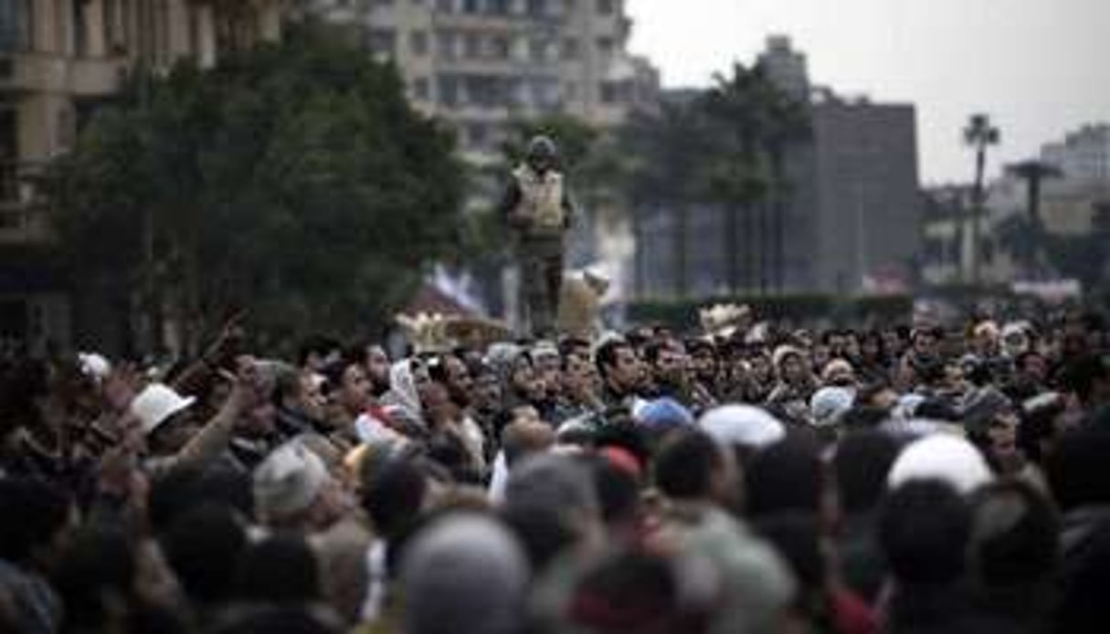 Manifestants anti-Moubarak rassemblés devant un char de l’armée sur la place Al-Tahrir au Caire. © AFP