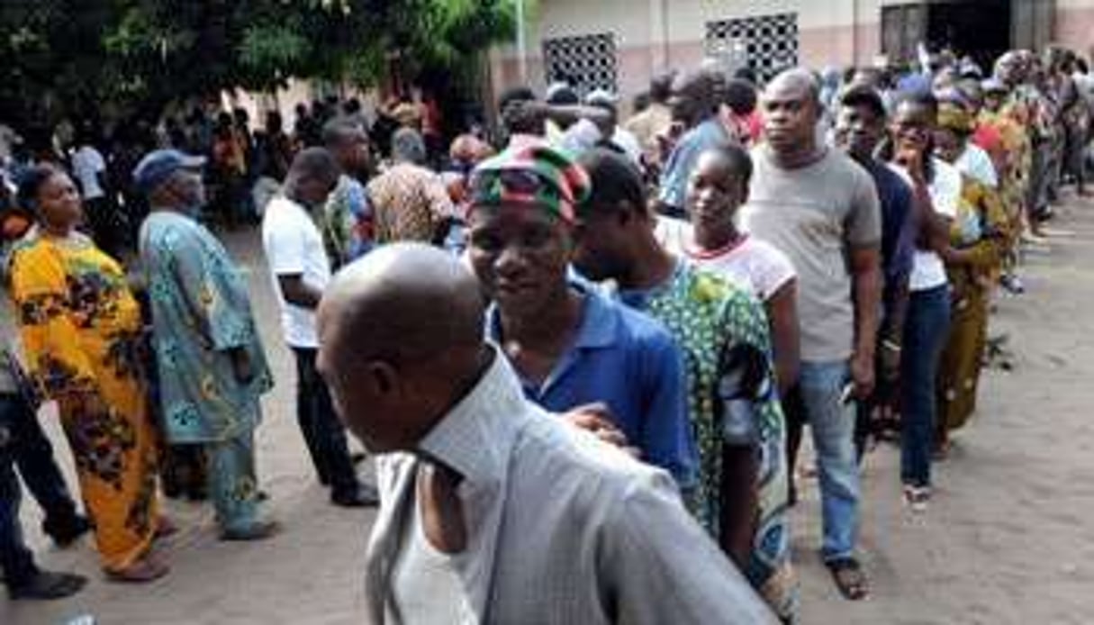 Des électeurs font la queue devant un bureau de vote à Cotonou, le 13 mars 2011. © AFP