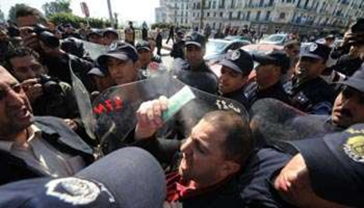 Un manifestant encerclé par la police, le 19 mars 2011 à Alger. © AFP