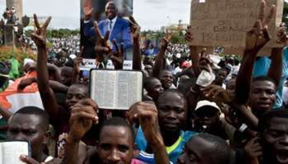 Des partisans de Laurent Gbagbo brandissent son portrait et des bibles, le 26 mars. © AFP