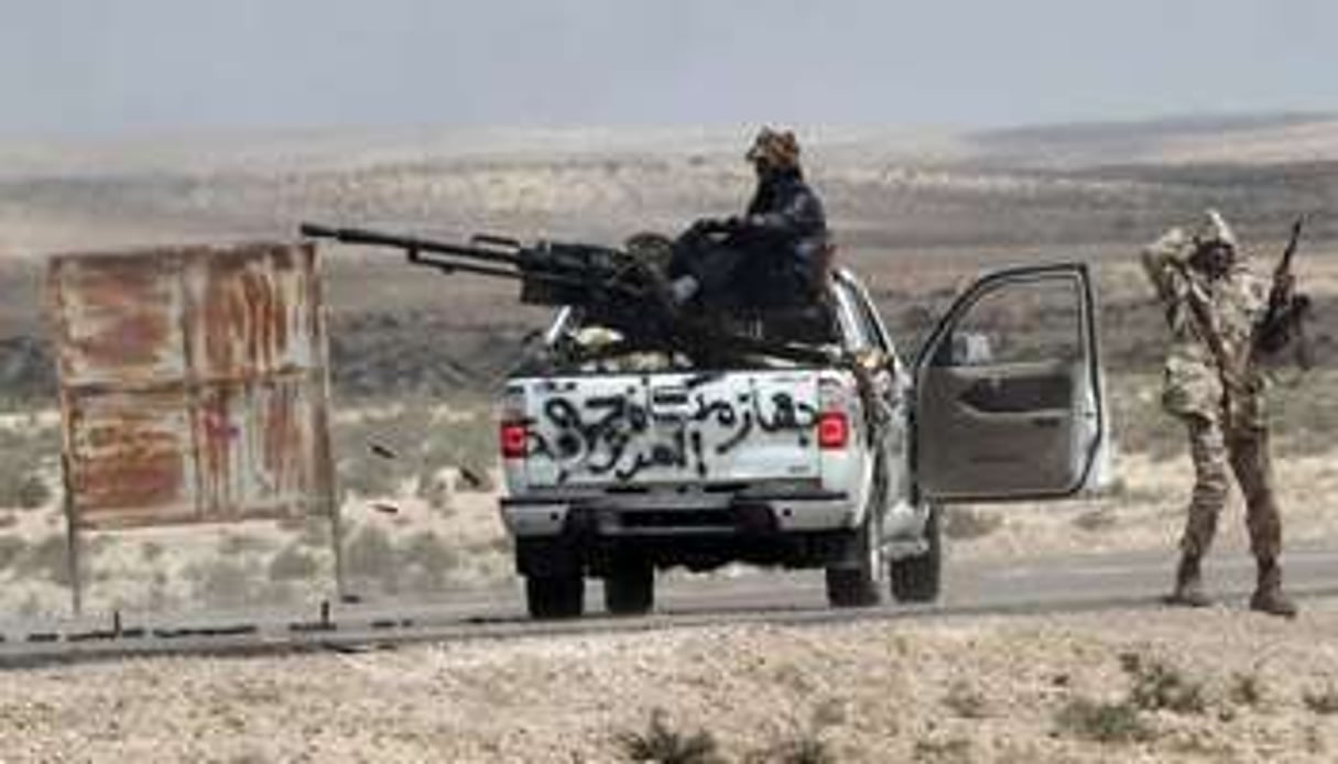 Des rebelles libyens prennent position près de Brega, le 31 mars. © AFP