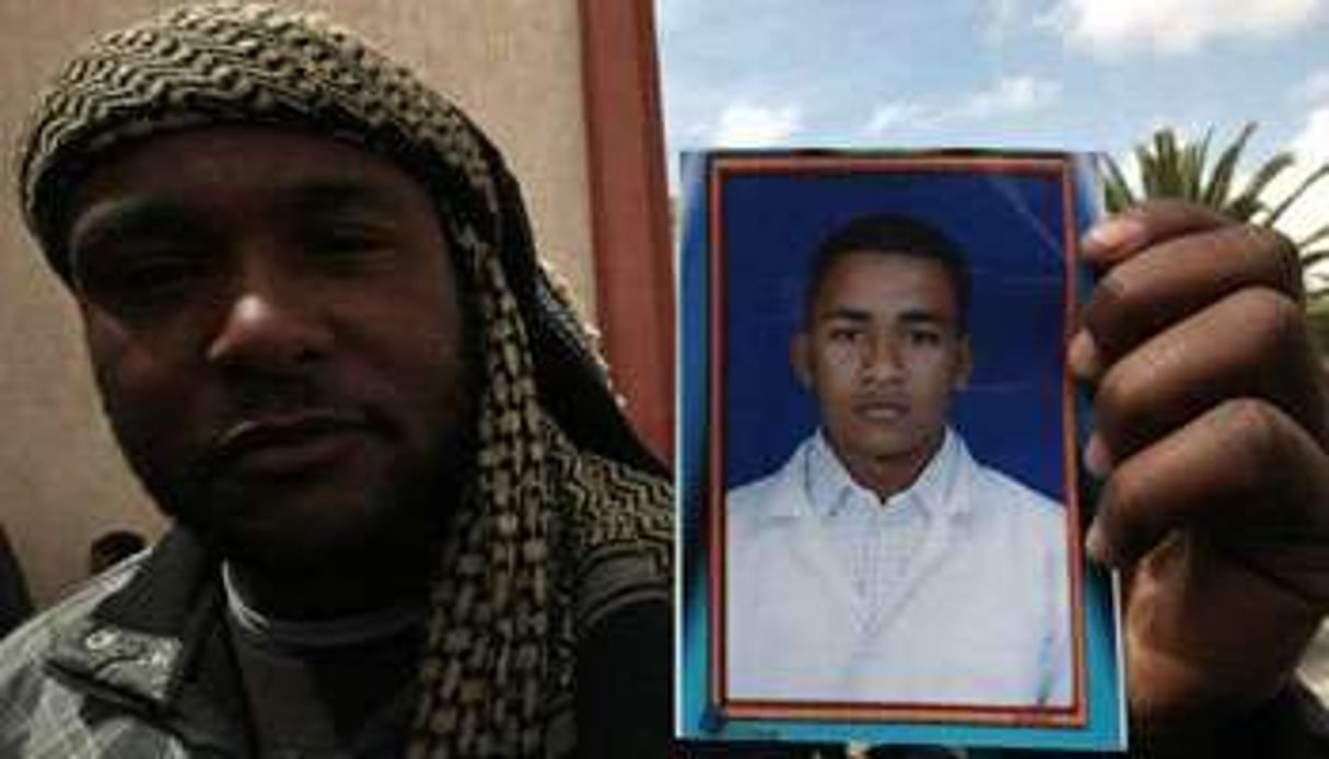 Un homme montre la photo de son frère, un civil tué dans une probable bavure de la coalition, le 2 © AFP