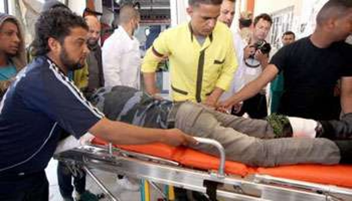 Un rebelle blessé transporté le 16 avril 2011 à l’hôpital d’Ajdabiya. © AFP