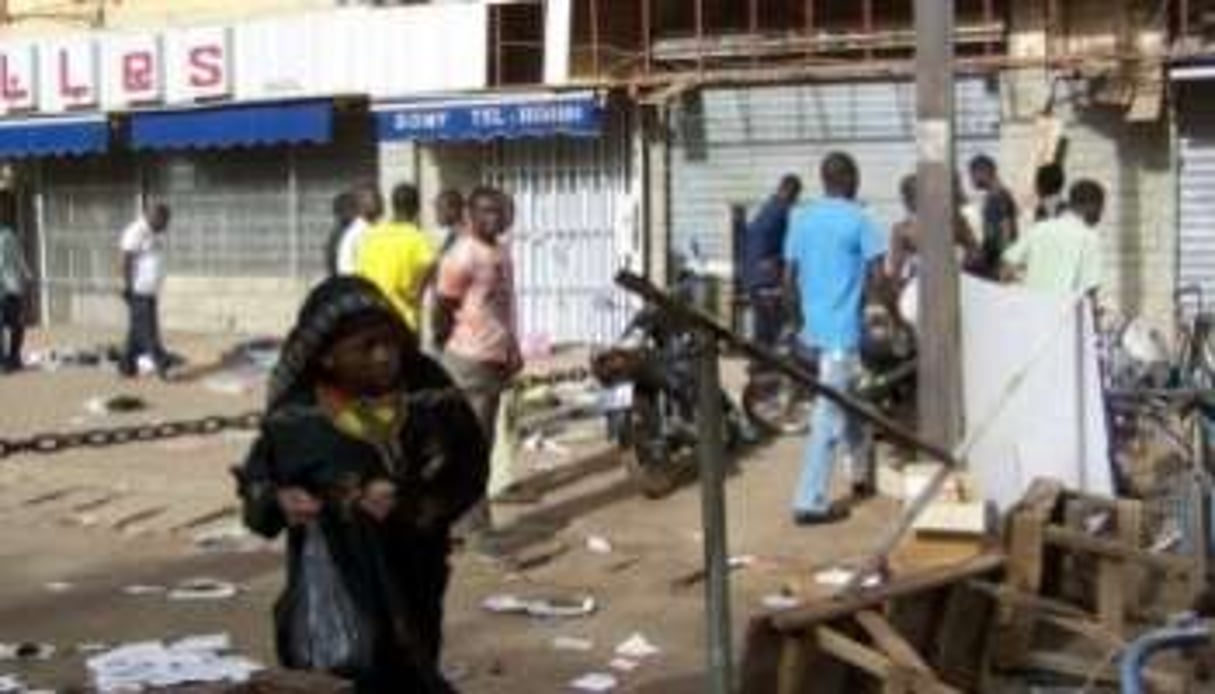 Des habitants de Ouagadougou constatent les dégâts dans une rue de la ville, le 16 avril 2011. © AFP