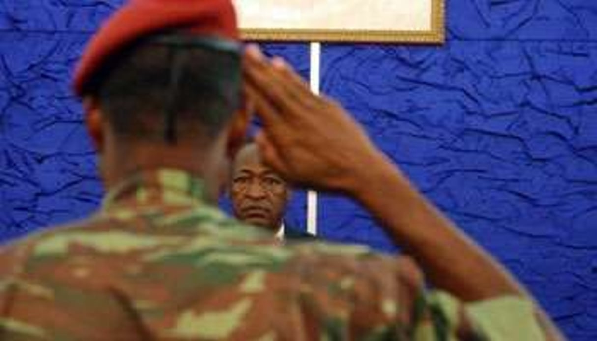 Le président burkinabè Blaise Compaoré est salué par un soldat, le 1er avril. © AFP
