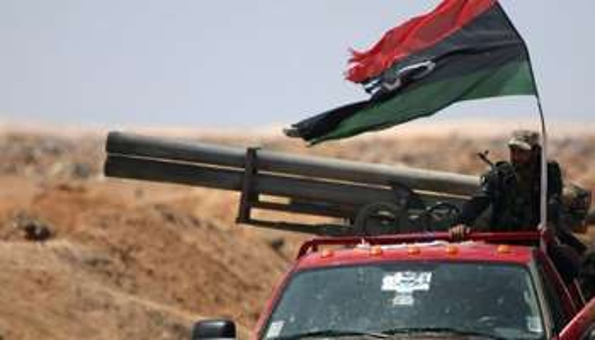Un rebelle libyen sur un pickup où est installé un lance-roquettes, près d’Ajdabiya, le 23 avril. © AFP
