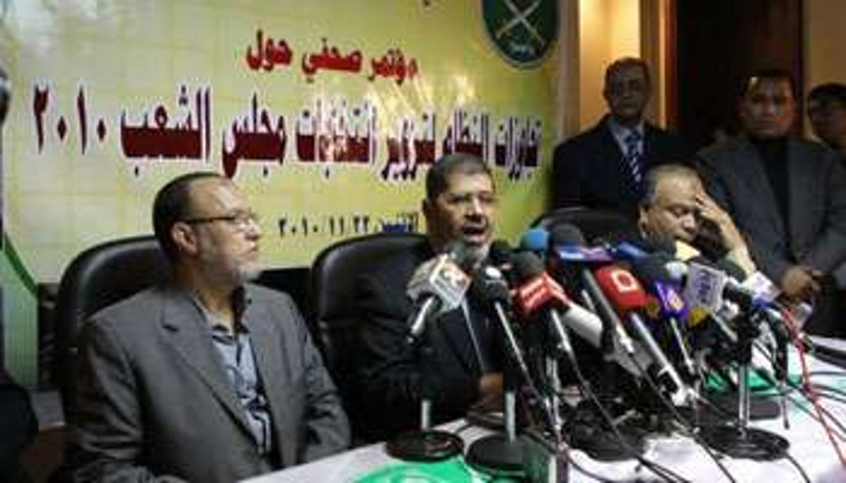 Le porte-parole des Frères musulmans Mohammed Mursi (centre) en novembre 2010. © AFP
