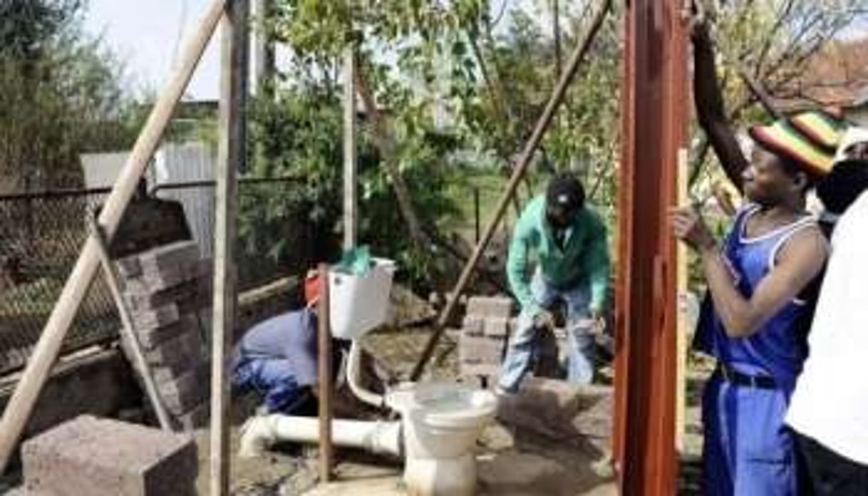Des ouvriers construisant des toilettes, dans le Rammulotsi township (province de Free State). © Stephane de Sakutin / AFP