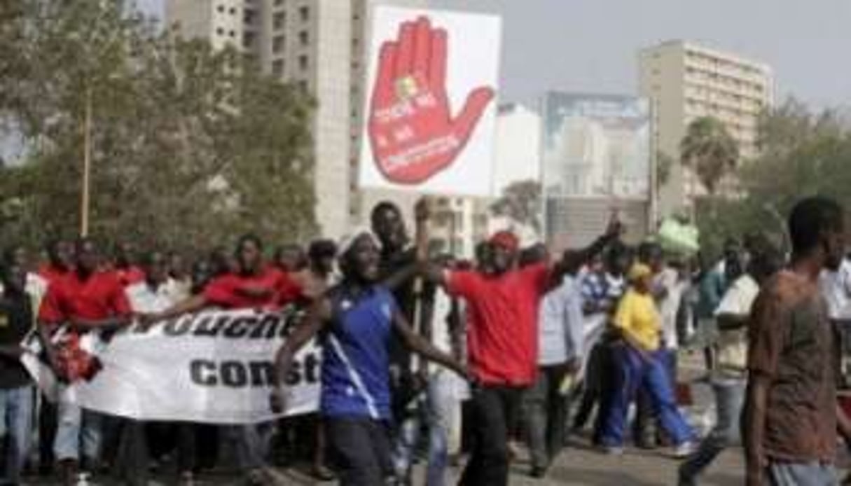 Des manifestants brandissent une pancarte: touche pas à ma constitution le 23 juin 2011 à Dakar. © AFP