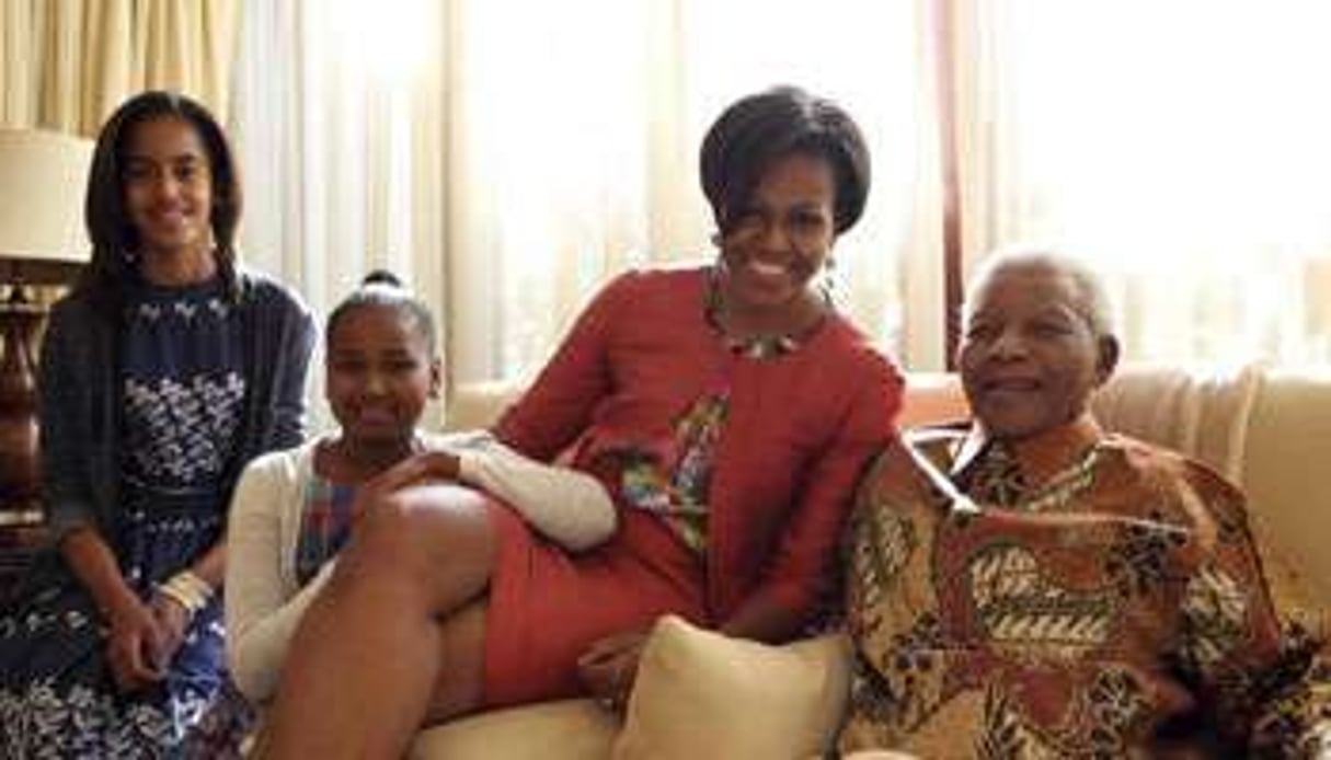 Michelle Obama et ses deux filles photographiées avec Nelson Mandela. © Reuters