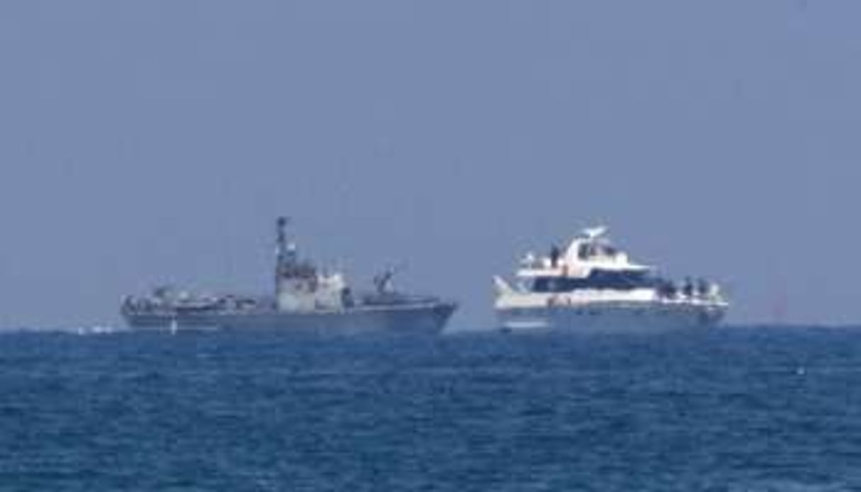 Un vaisseau militaire israélien (à g.) escorte l’un des bateaux de la flottille, le 31 mai 2010. © AFP