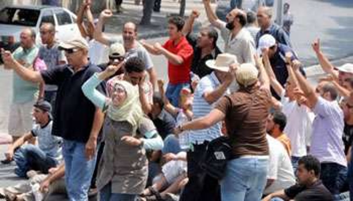 Des manifestants tunisiens scandent des slogans face aux forces de police à Tunis, le 15 juillet. © AFP