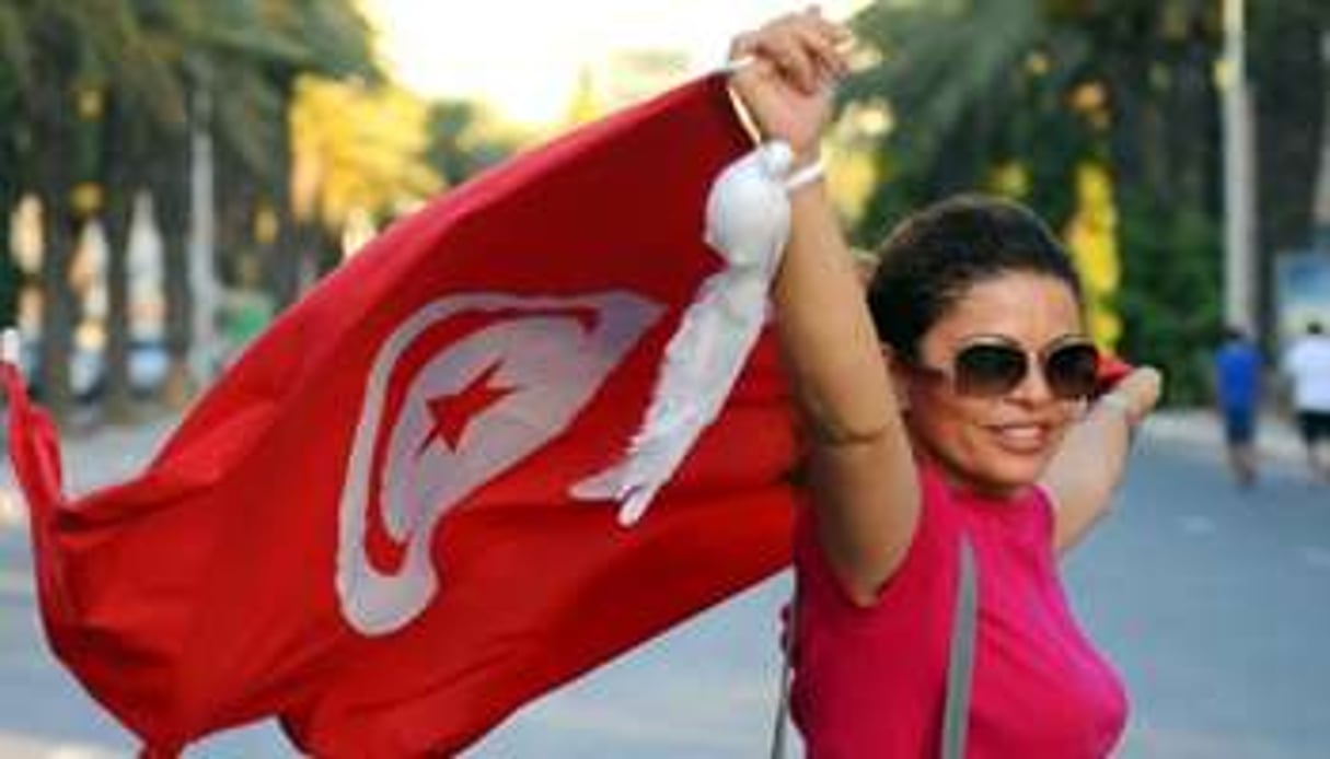 Une femme brandit le drapeau tunisien lors d’une marche contre le terrorisme et l’intégrisme à Tun © AFP
