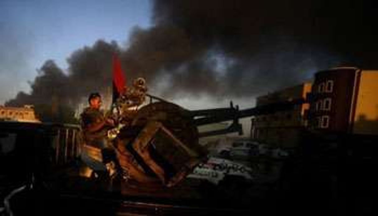 Des rebelles combattent le 26 août 2011 à Abu Salim dans la banlieue de Tripoli. © Filippo Monteforte/AFP