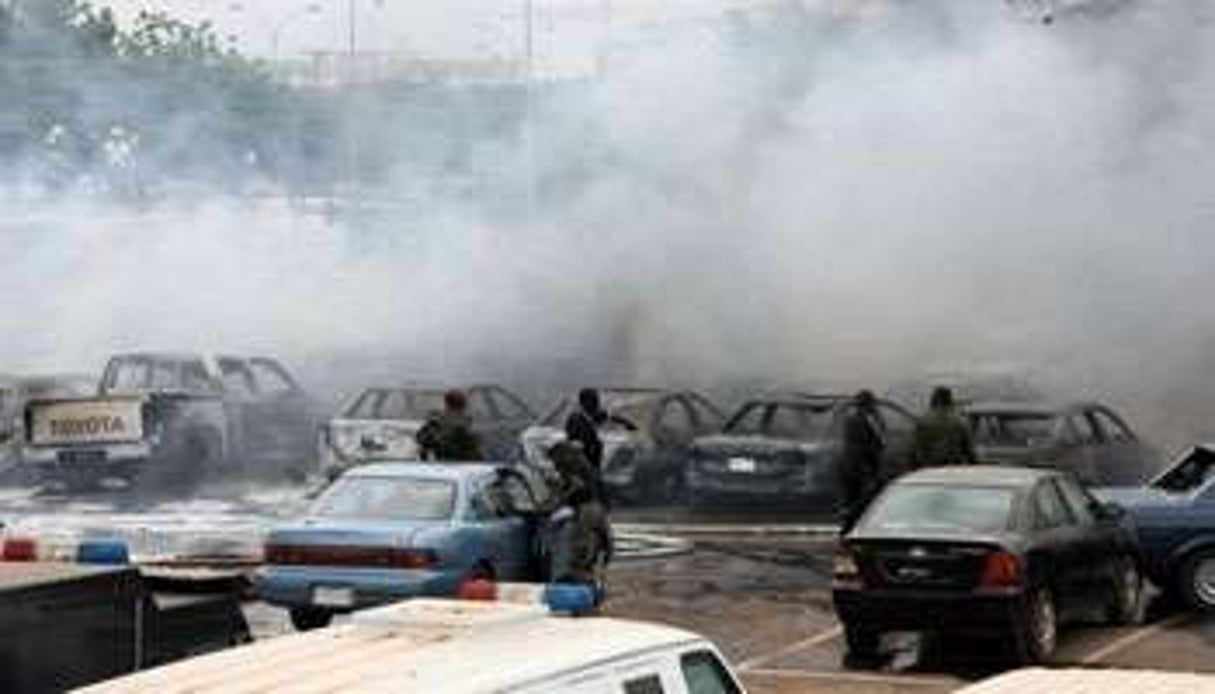 De la fumée au-dessus de véhicules endommagés par l’explosion d’une bombe, le 16 juin 2011. © Sunday Aghaeze/AFP