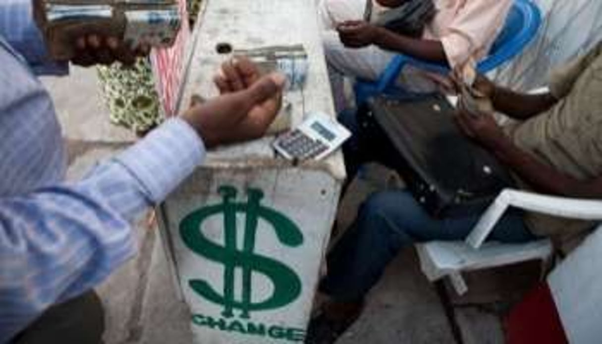 Un homme change un billet de 200 dollars en francs congolais le 19 novembre 2010 à Kinshasa. © AFP