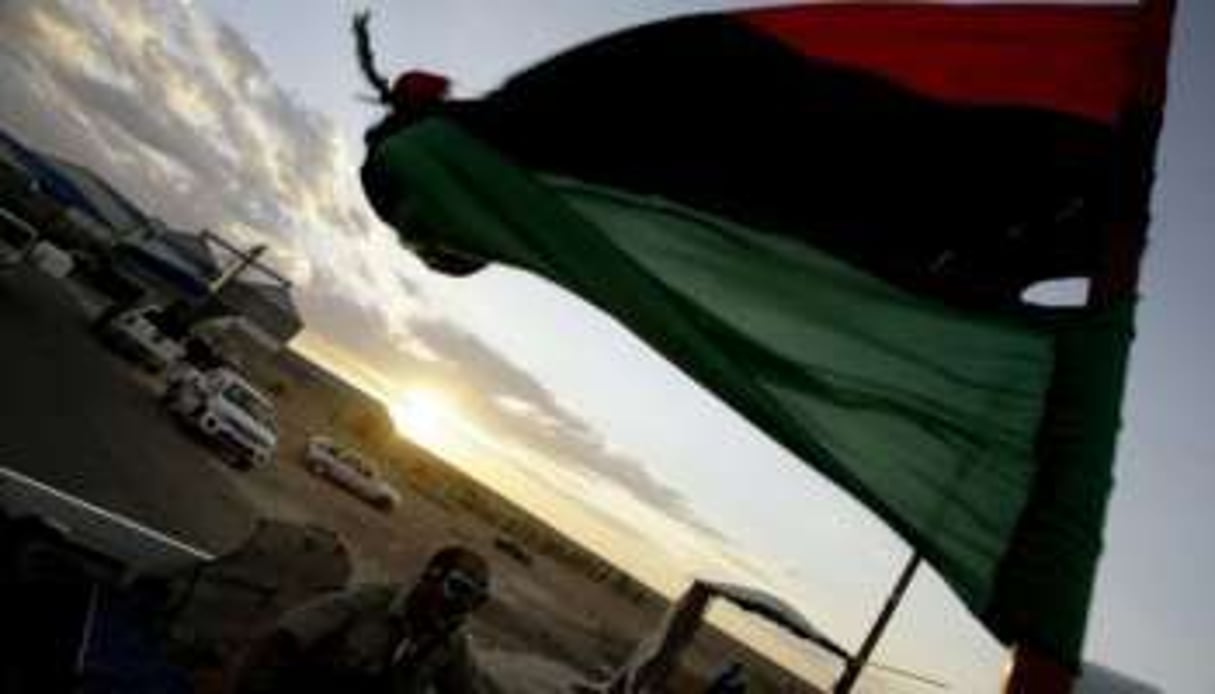Le drapeau libyen érigé par un combattant qui se dirige vers Bani Walid, le 10 septembre 2011. © AFP