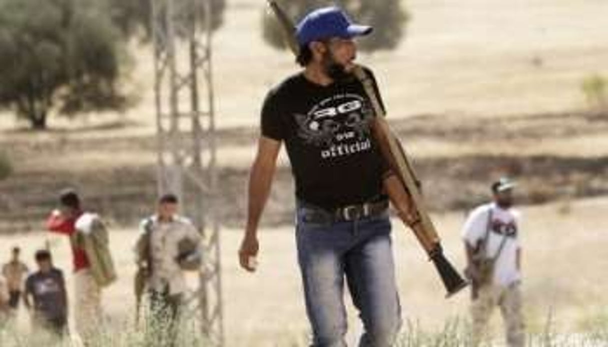 Des rebelles prennent position sur la route principale vers Kikla, le 13 juillet 2011. © AFP